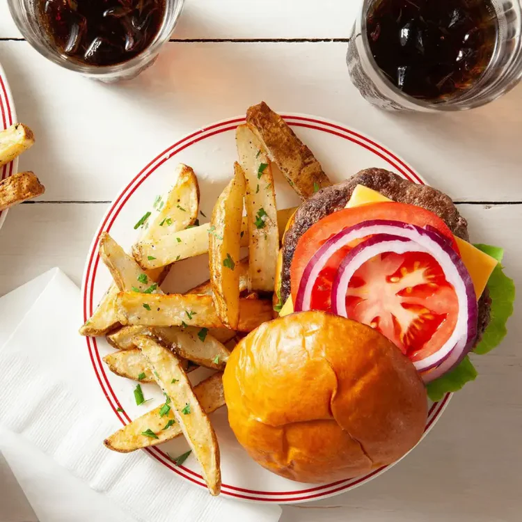 Plato saludable preparado en freidora de aire: hamburguesa con papas y vegetales frescos